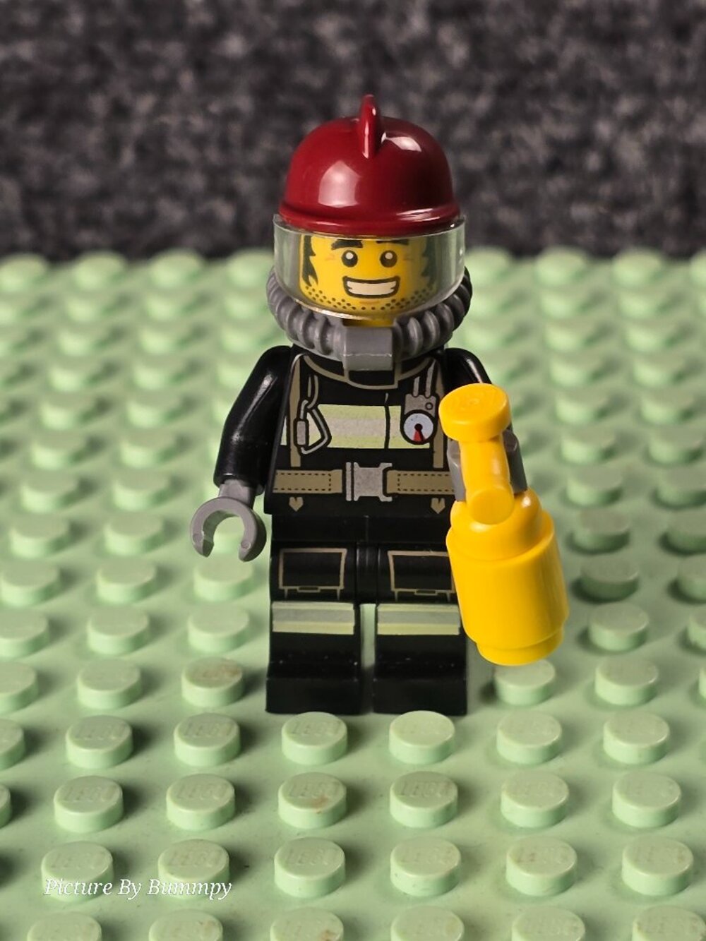 LEGO City Firefighter minifigure with a red helmet and yellow fire extinguisher.